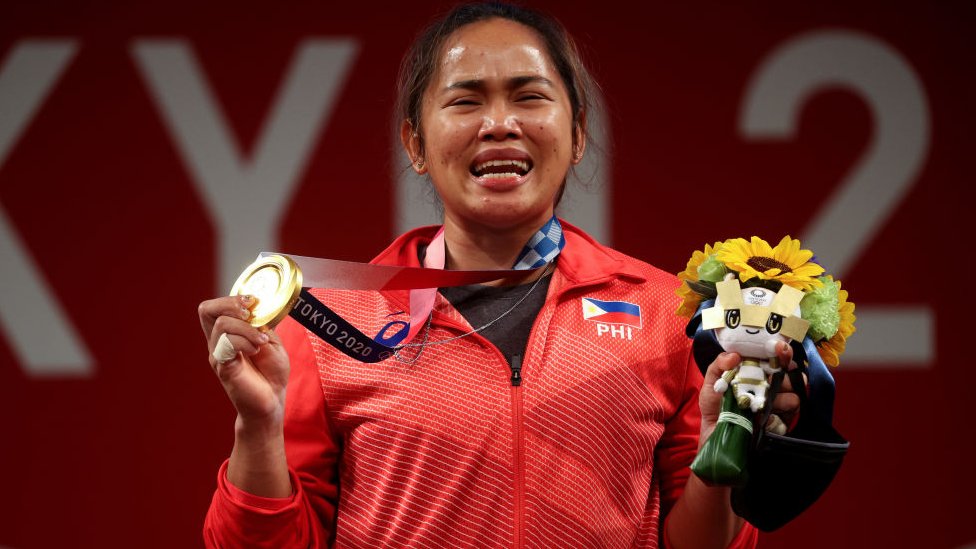 Hidilyn Diaz chorando ao mostrar sua medalha de ouro em Tóqui