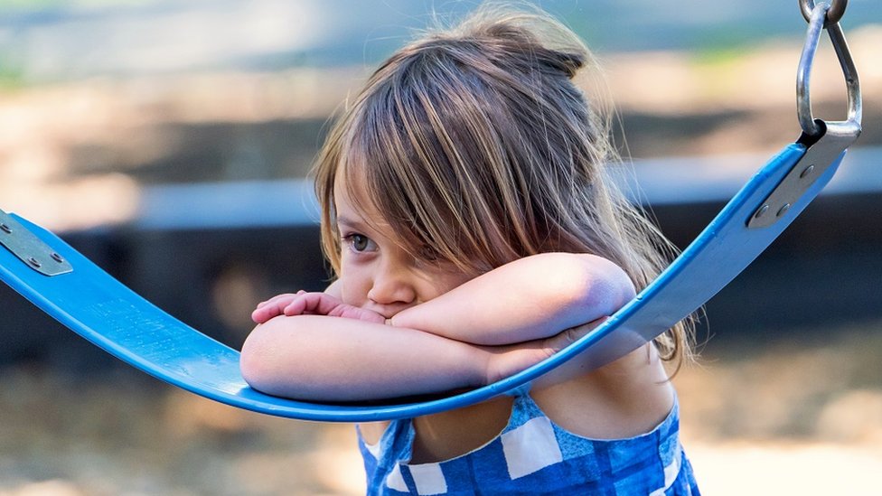 Una niña sola en un columpio.