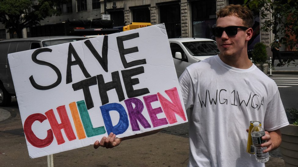 Человек в футболке с анаграммой WWG1WGA, слоганом QAnon, участвует в марше и митинге «Спасите детей» в Нью-Йорке, Нью-Йорк, США 12 августа 2020 г.