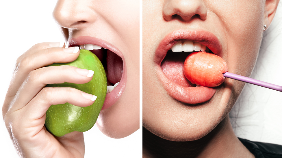 Žena jede jabuku, a druga liže lizalicu