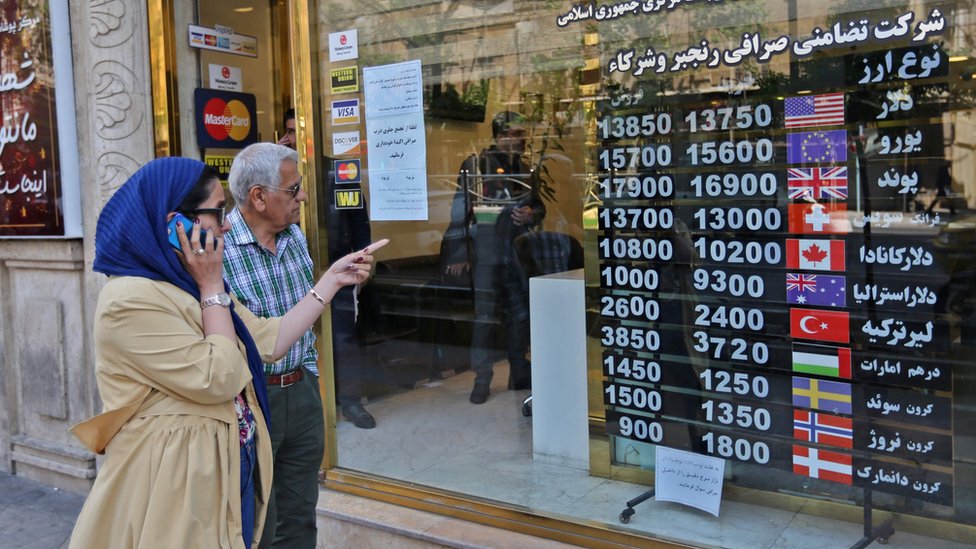 Люди проходят мимо обменного пункта в Тегеране, Иран (22 апреля 2019 г.)