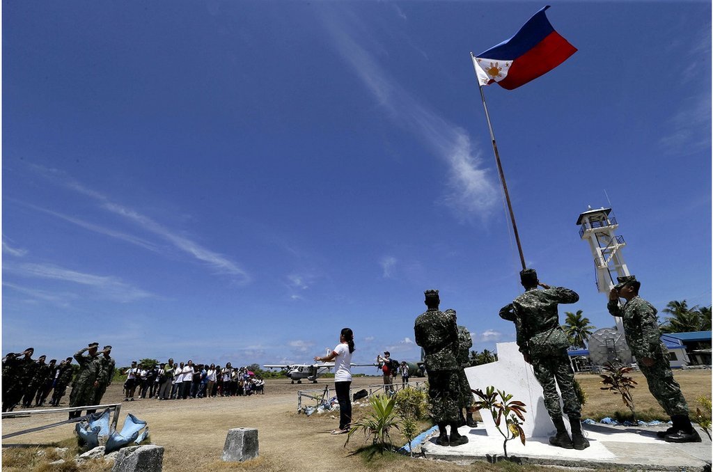 2015年5月，菲律賓武裝部隊總參謀長卡塔龐訪問菲律賓巴拉望島以西南中國海南沙群島中業島期間，菲律賓居民和士兵舉行升旗儀式。路透社/Ritchie A. Morning/Pool/File Photo