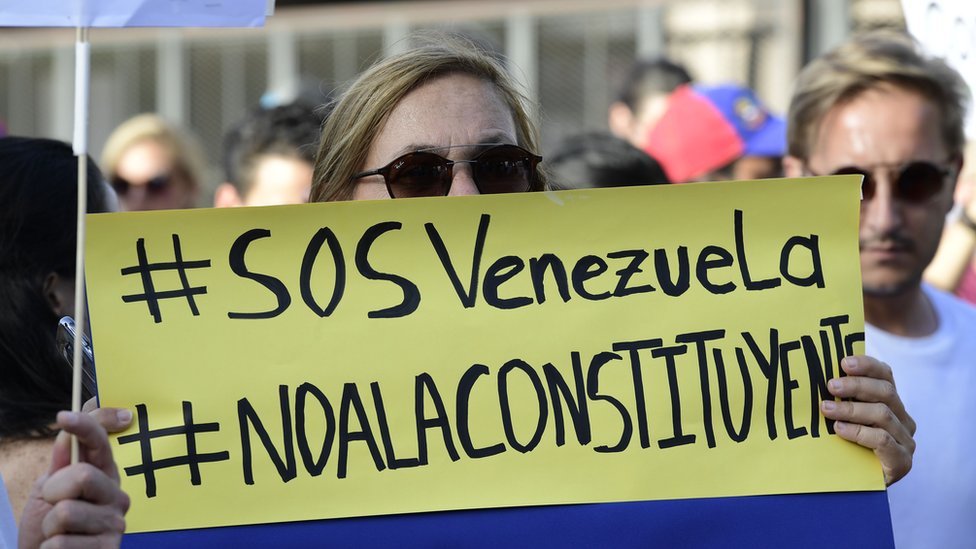 Венесуэлец держит плакат во время акции протеста 30 июля 2017 года против президента Венесуэлы Николаса Мадуро и выборов в Учредительное собрание