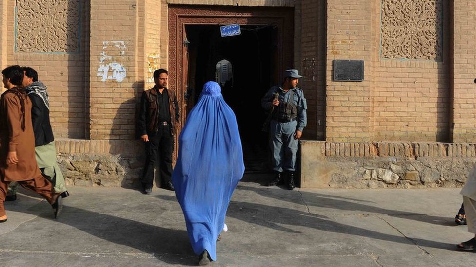 Una mujer entra en un edificio en Herat