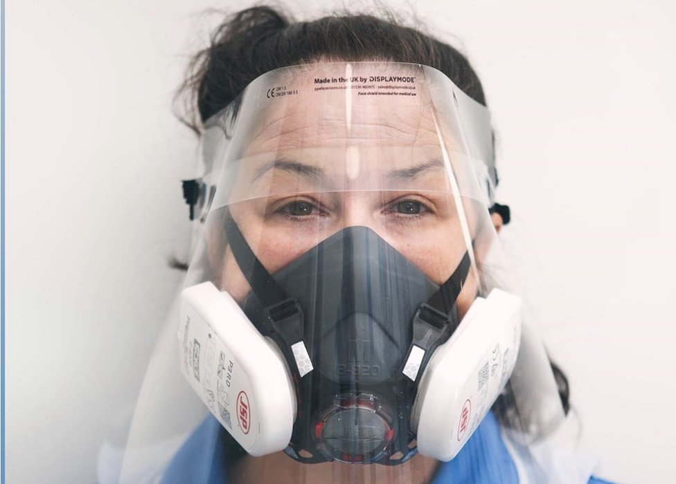 Джоди Бонд, медсестра, получающая незапланированный уход в Norfolk Community Health and Care NHS Trust, носит защитную маску и респиратор