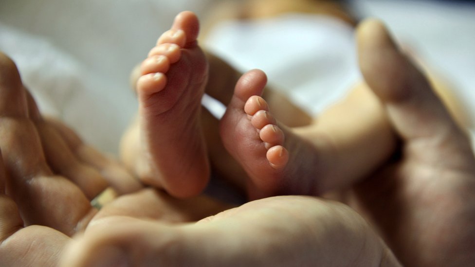 Ножки младенца в руках