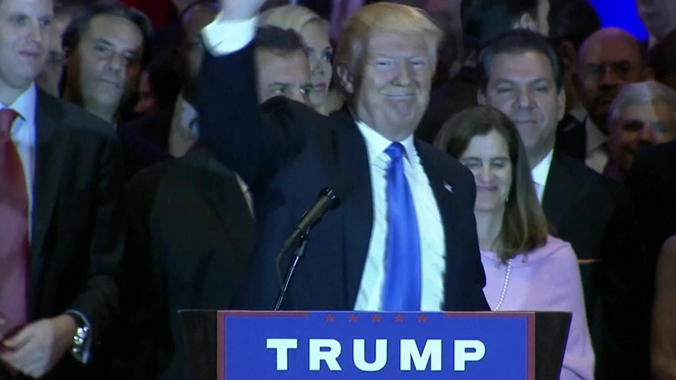 Trump at podium waving