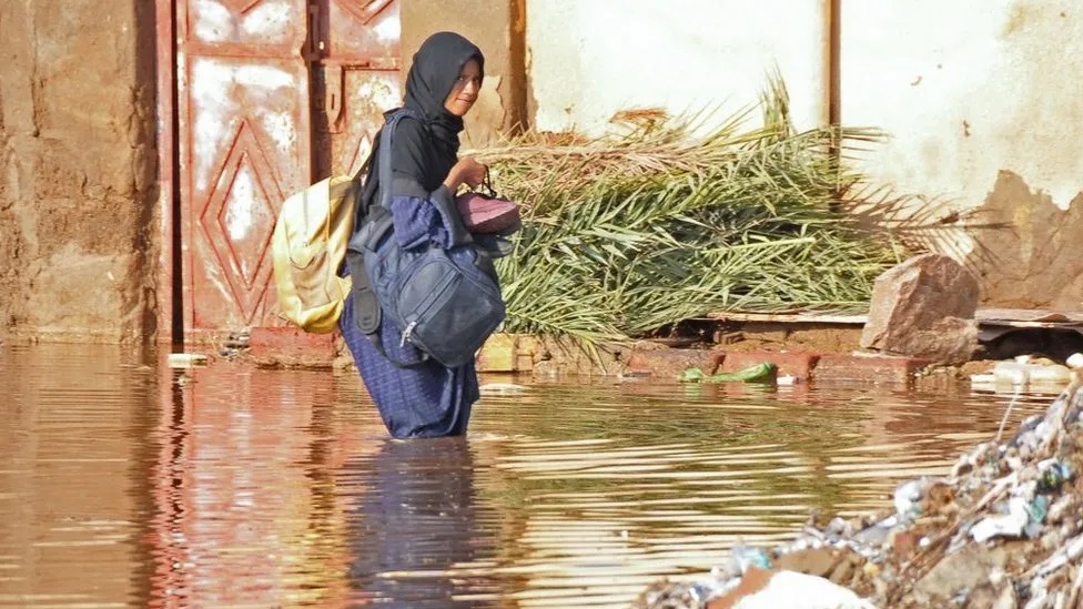 Mulher atravessa área alagada no Sudão