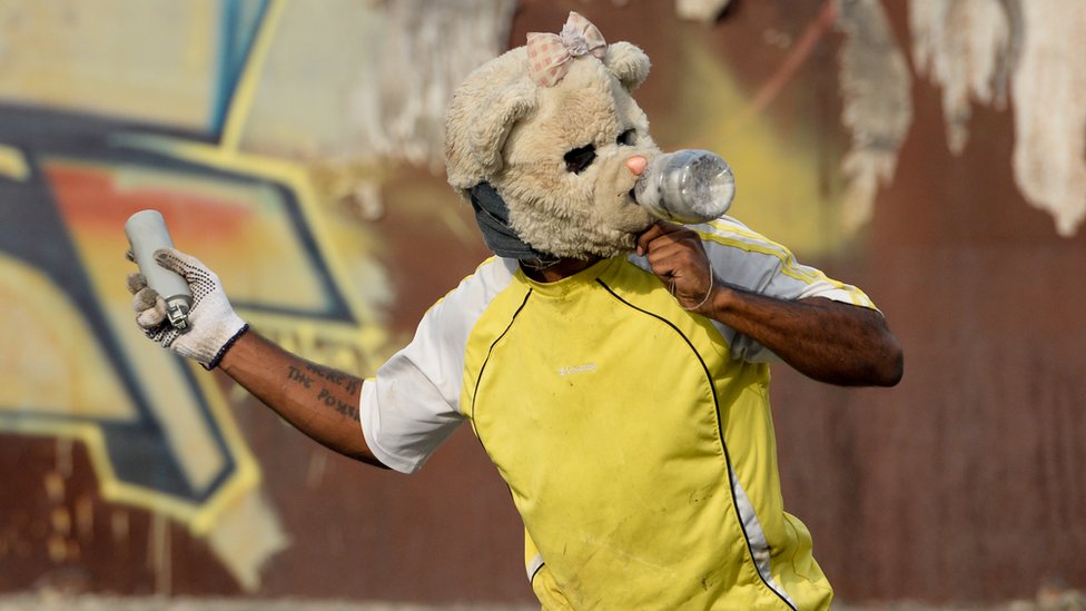 Un manifestante en Caracas, Venezuela, a punto de lanzar una lata de gas lacrimógeno. Hombre a punto de lanzar una bomba lacrimógena en Caracas, Venezuela.