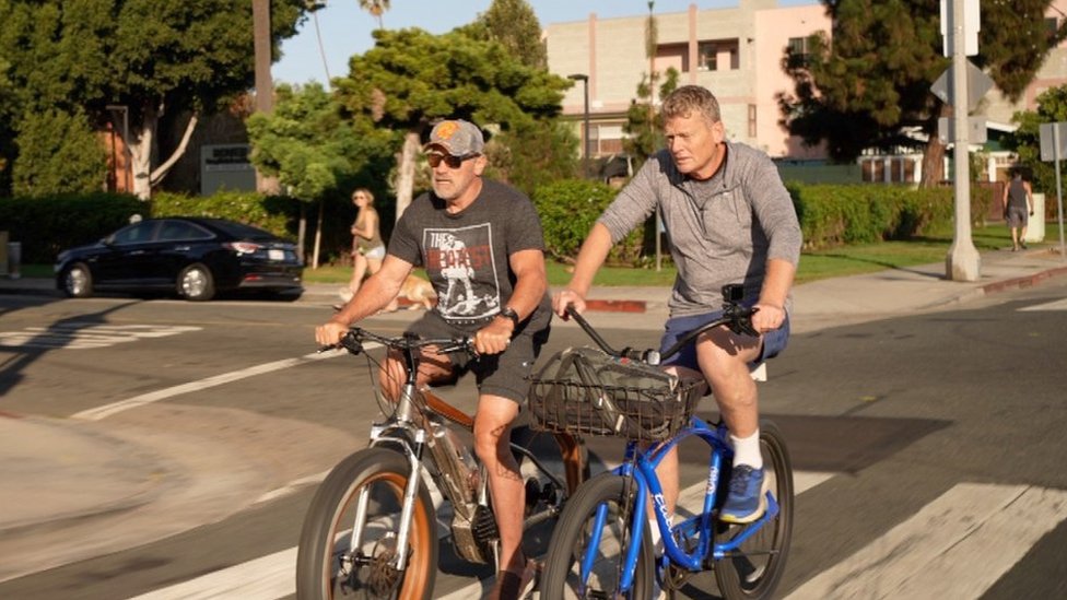 Arnold Švarceneger i Tom Hip voze bicikle