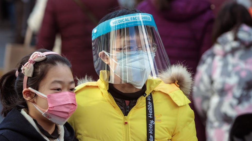 A man and a child wearing face masks in China