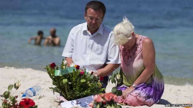 Tourists mourn at the site of a shooting attack on the beach
