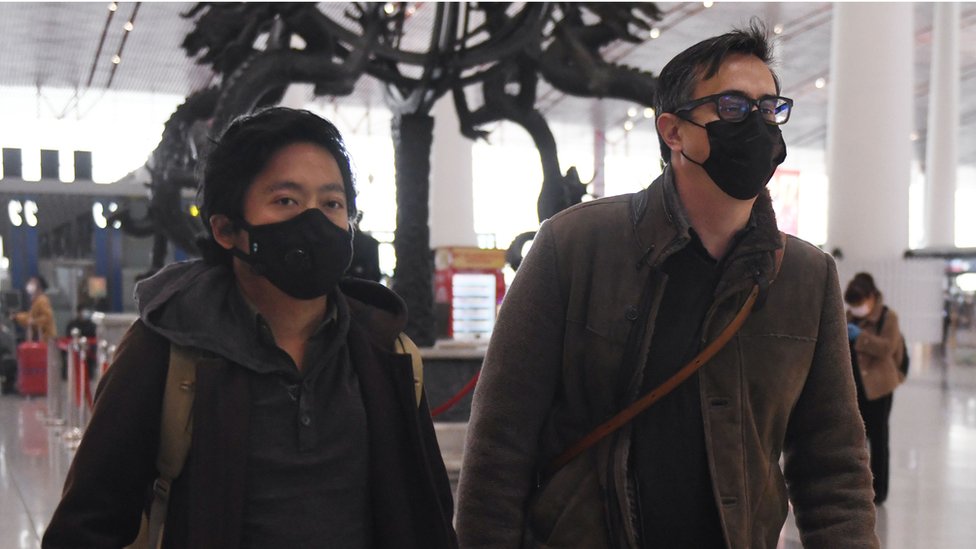 Wall Street Journal reporters Josh Chin (R) and Philip Wen walk through Beijing Capital Airport before their departure on February 24, 2020.