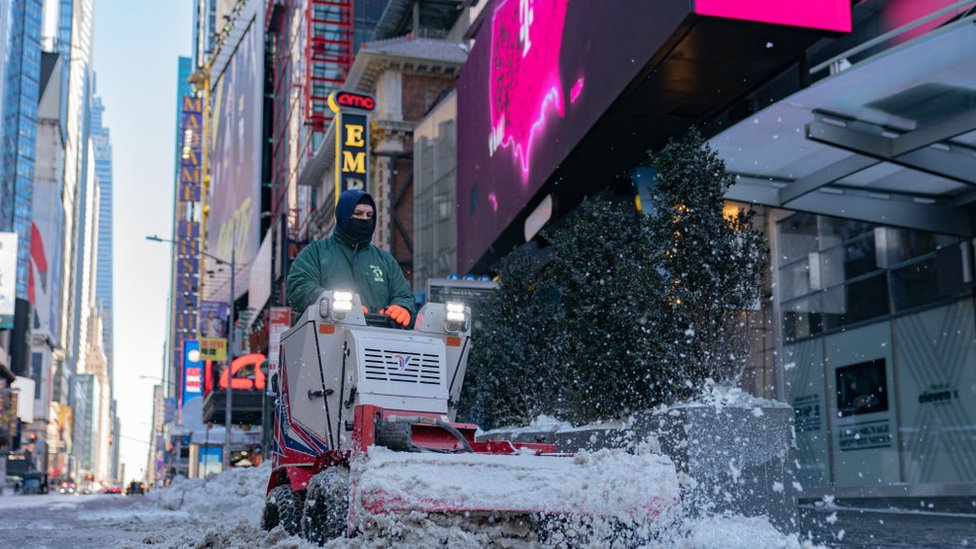 عامل يقوم بإزالة الثلج في تايمز سكوير في نيويورك