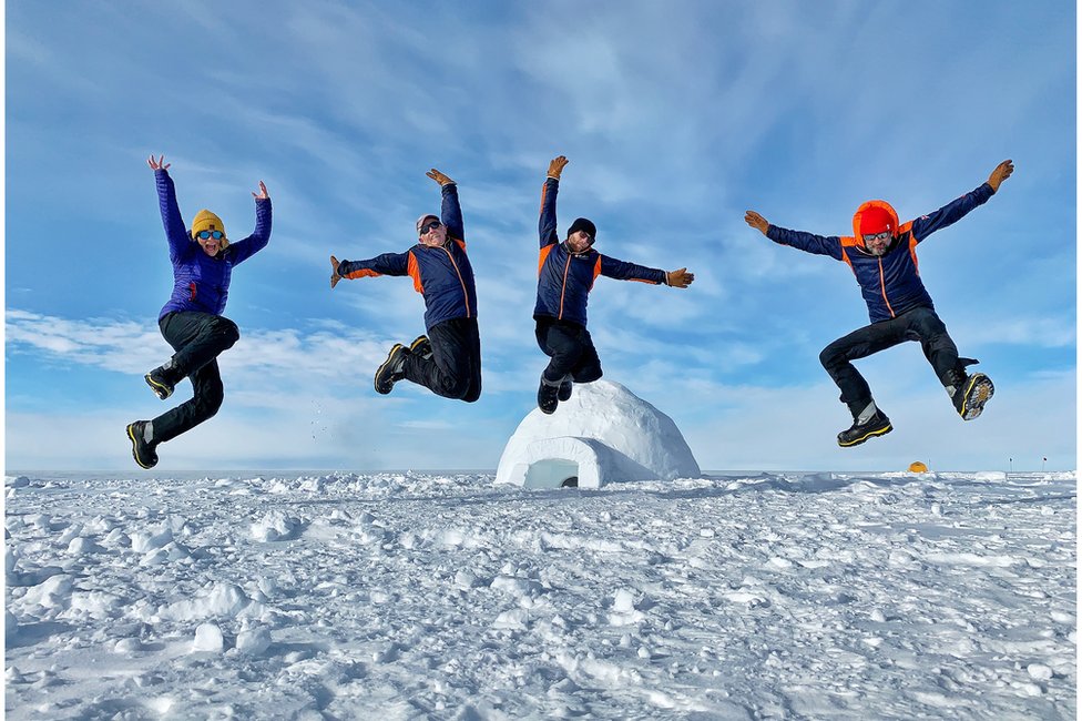 Джастин Роулат (справа) прыгает с коллегами и ученым в Антарктиде