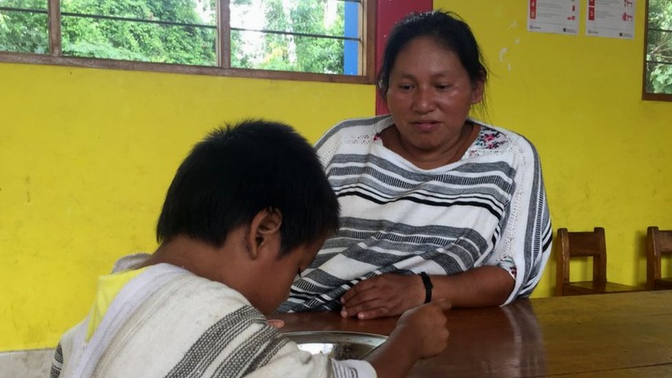 Romelia Rivera Italiano le enseña a un niño