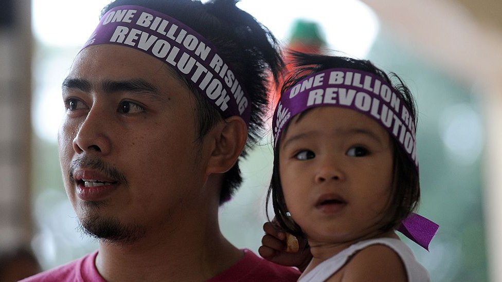 Padre junto su hija durante una campaña defensora de los derechos del niño en Filipinas.