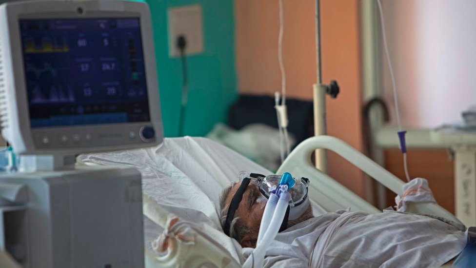 In this photograph taken on July 15, 2020 a COVID-19 coronavirus patient lies on a bed at the Intensive Care Unit of the Sharda Hospital, in Greater Noida