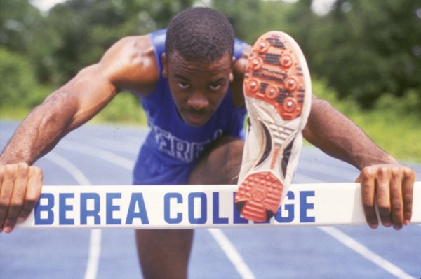 Estudiante de Berea College saltando un obstáculo en una pista de atletismo.