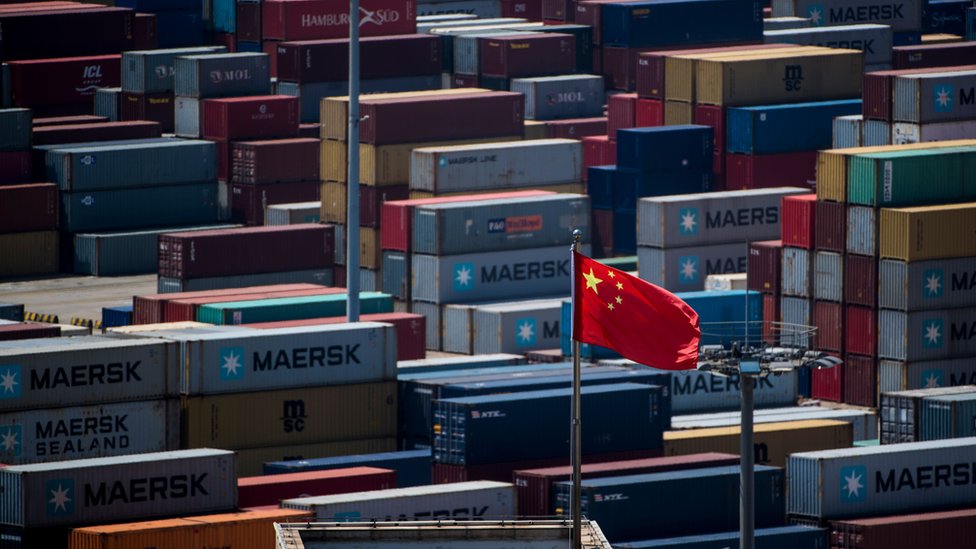 Китайский флаг перед контейнерами в глубоководном порту Яншань, автоматизированной грузовой пристани в Шанхае, 9 апреля 2018 года.