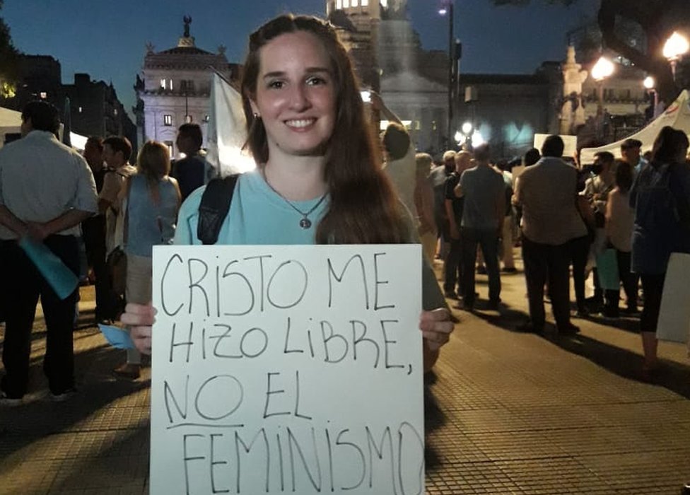 Belu Lombardi holds a sing reading "Feminism didn't set me free, Christ did"