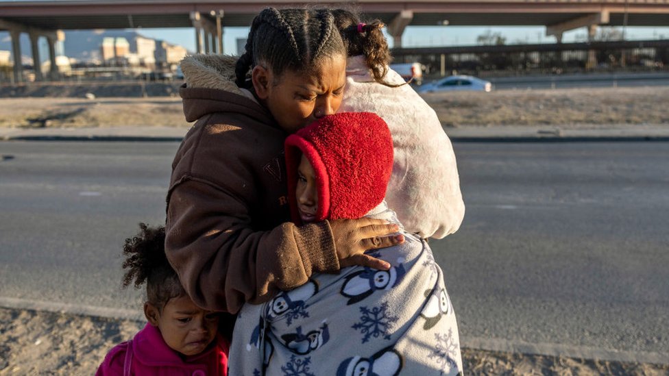La migrante venezolana Yaneisi abraza a sus tres hijos en Ciudad Juárez, México, después del despliegue de la Guardia Nacional de Texas al otro lado del río Bravo, en El Paso, Texas, Estados Unidos, el 20 de diciembre de 2022.