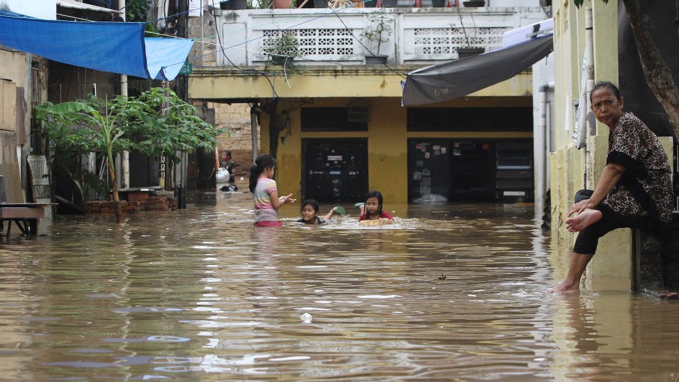 Habitantes durante una inundación en Yakarta.