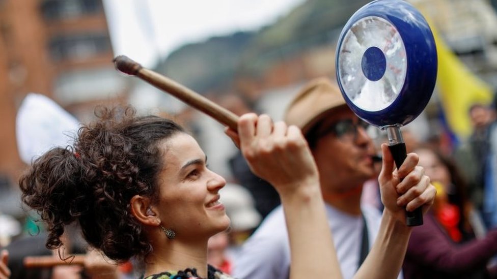 Женщина бьет кастрюлю во время акции протеста в Боготе 27 ноября 2019 года