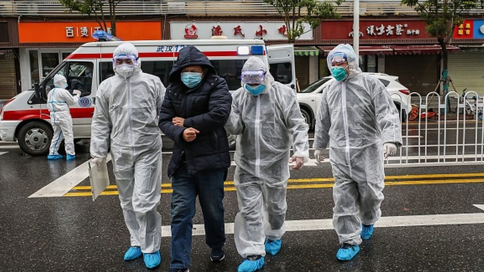 فريق طبي صيني ومعهم مصاب بالفيروس في مدينة ووهان