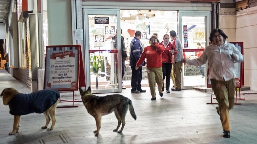 Люди выходят из супермаркета во время сильного землетрясения в Сантьяго 16 сентября 2015 года.