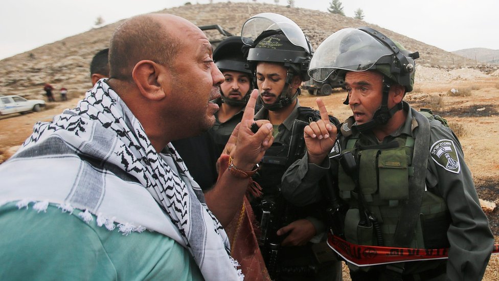 Протестующий из Палестины спорит с израильским пограничником возле Хеврона на оккупированном Западном берегу (15 ноября 2019 г.)