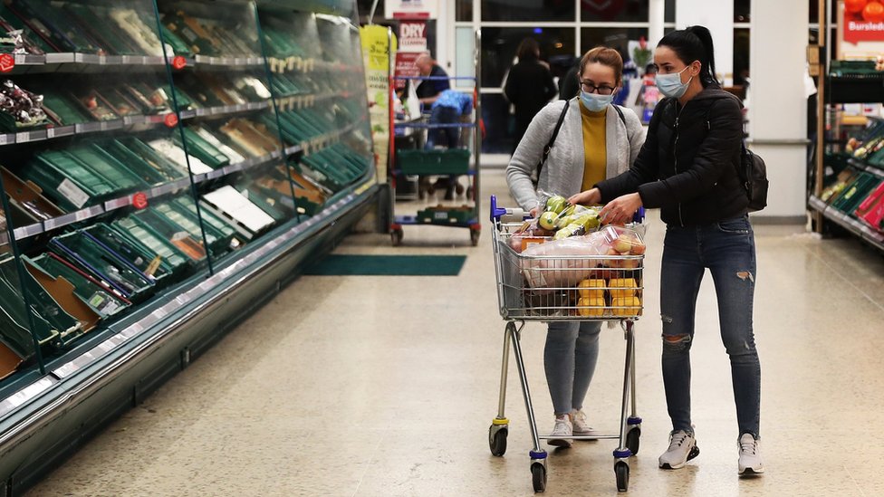 18 марта 2020 года в Саутгемптоне, Великобритания, в магазине Tesco покупатели в масках делают покупки в супермаркете.