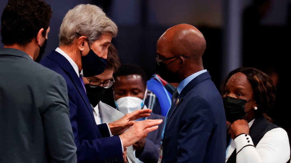 El enviado de Estados Unidos para el clima, John Kerry, habla con el delegado de la COP26