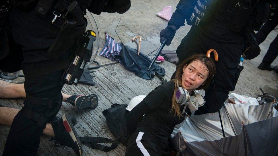 Estudiante arrestada en el suelo en Hong Kong.