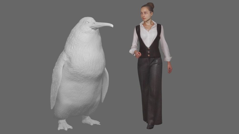 Modelo del pingüino al lado de una mujer.