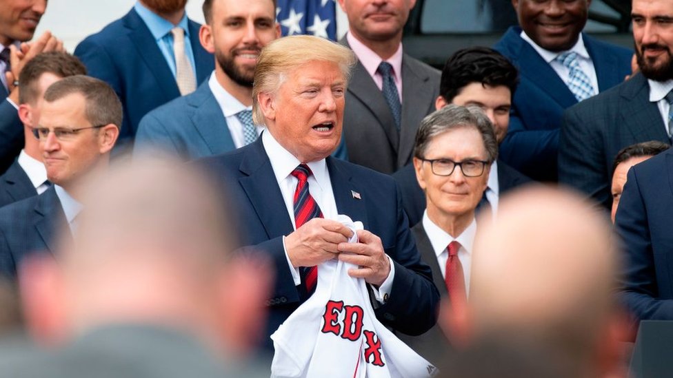 Президент США Дональд Трамп (C) держит майку Boston Redsox, которую ему подарили, когда он приветствовал чемпионов Мировой серии 2018 года в Белом доме в Вашингтоне, округ Колумбия, 9 мая 2019 года