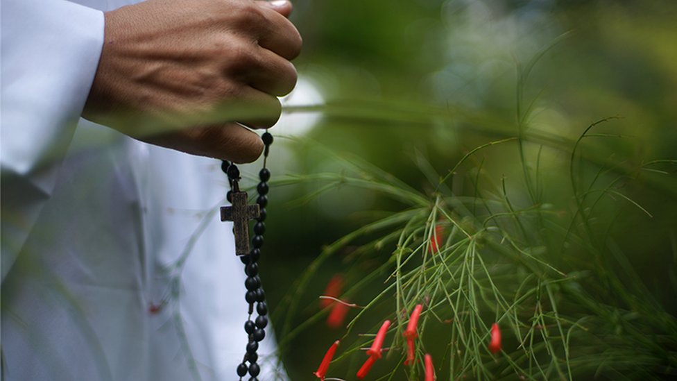 Una mano sosteniendo un rosario