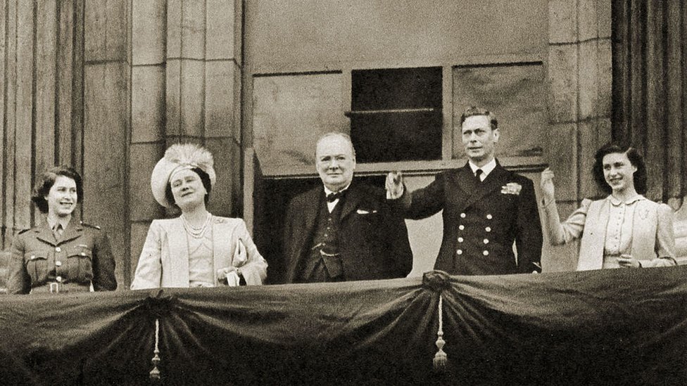 Премьер-министр военного времени Уинстон Черчилль стоит на балконе Букингемского дворца рядом с королевской семьей (с королевой, затем принцессой Елизаветой, слева) в День Победы, 8 мая 1945 года