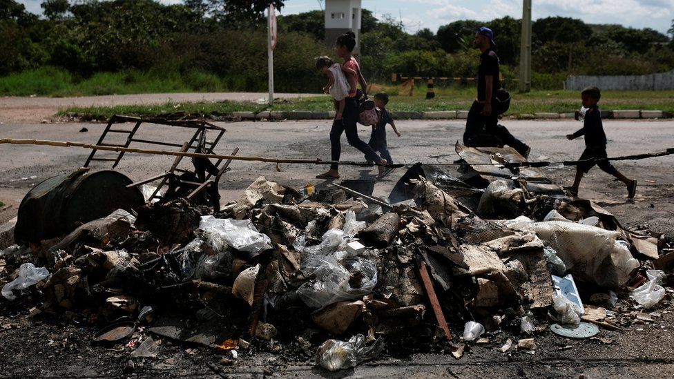 Venezolanos frente a tiendas de campaña quemadas en protesta el sábado