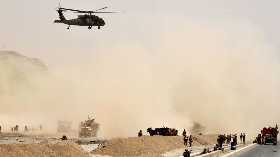 Un helicóptero negro de Estados Unidos vuela sobre el sitio de un ataque suicida talibán en Kandahar.