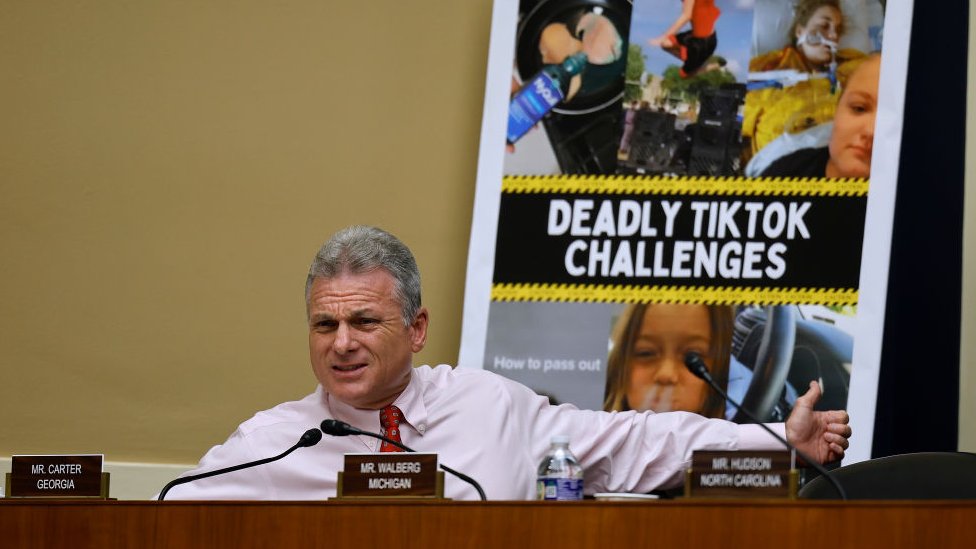 A congressman shows a sign about deadly challenges on TikTok