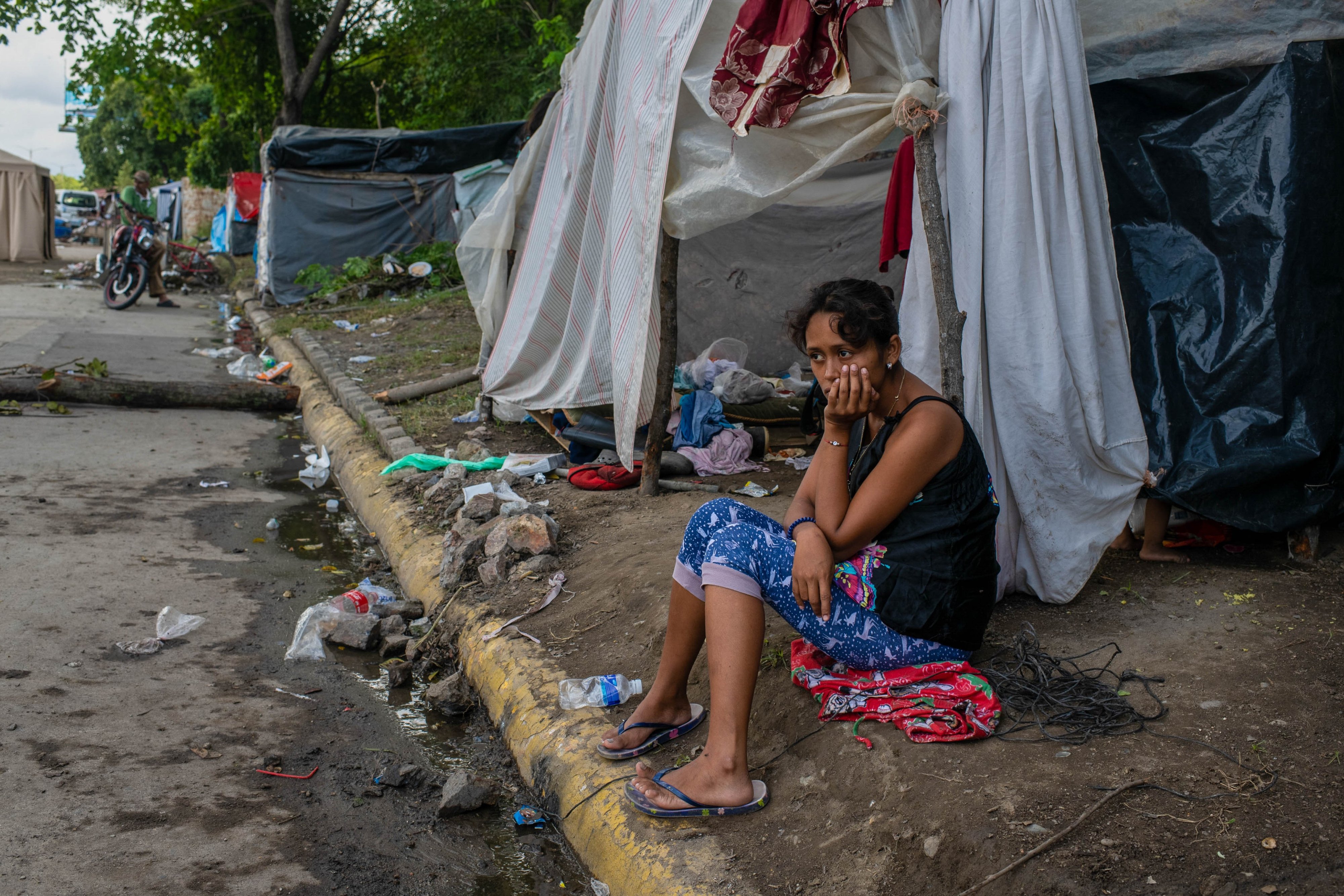 Сьюзан Есения Агилар сидит перед импровизированной палаткой, в которой она жила после наводнения.