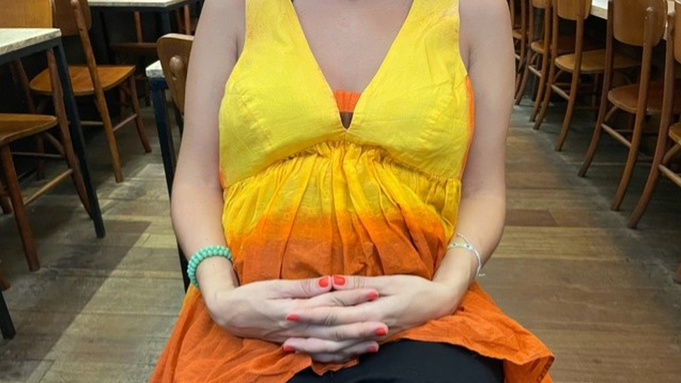 A woman holding her pregnancy bump