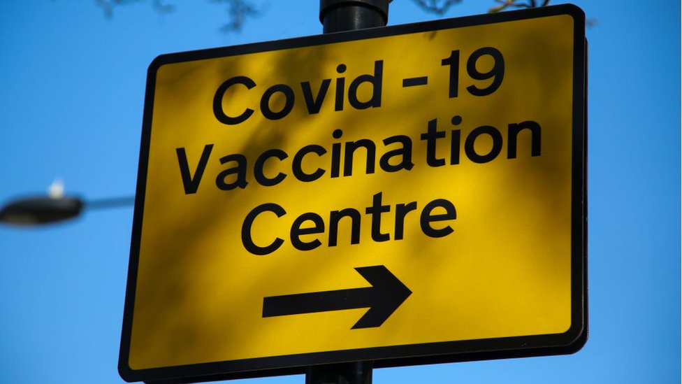 علامة تدل على اتجاه مركز تطعيم لكوفيد - 19 في لندن