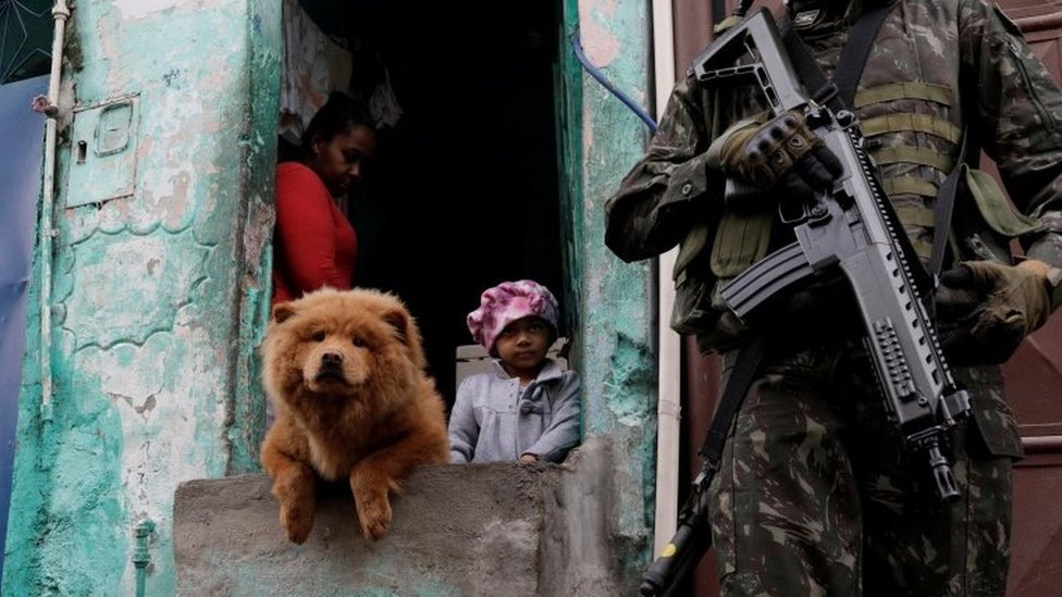 Военнослужащие патрулируют под наблюдением жителей во время операции против организованной преступности в трущобном комплексе Мангиньос в Рио-де-Жанейро, Бразилия, 21 августа 2017 г.