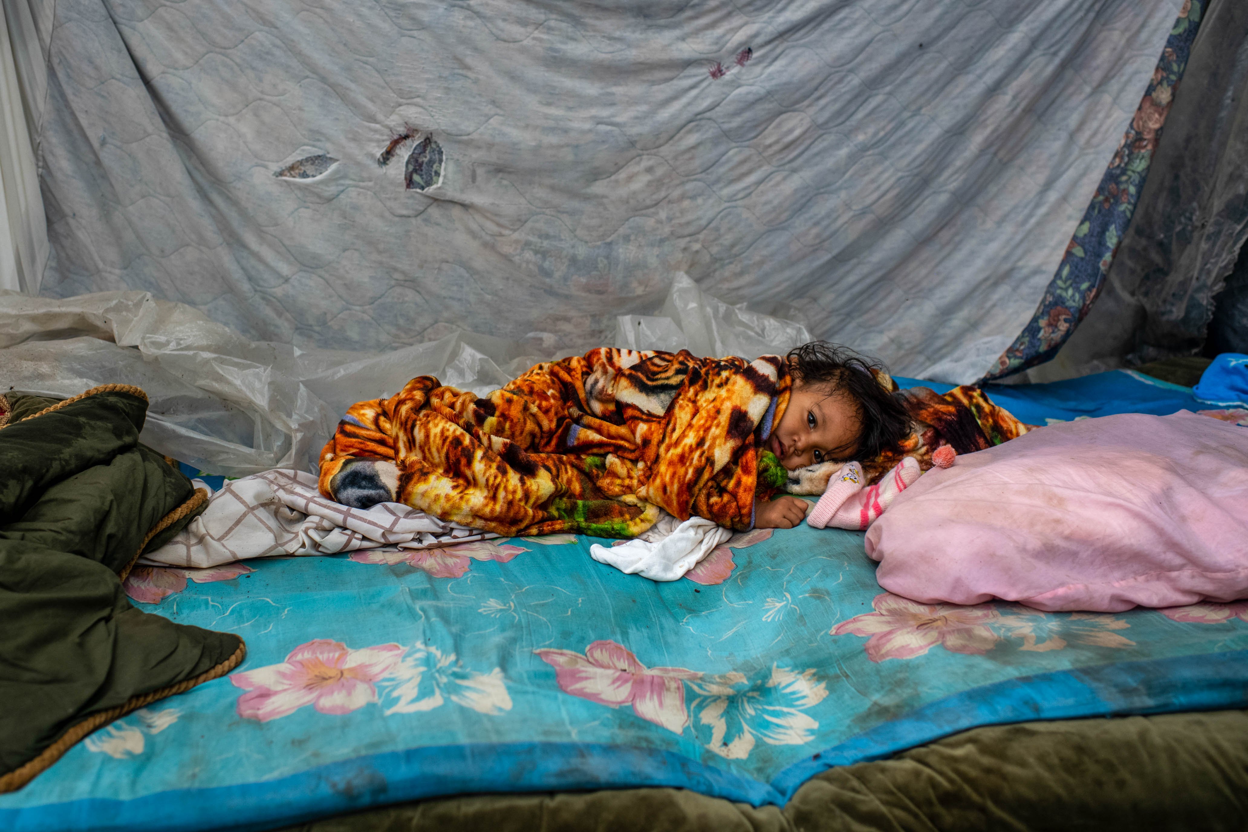 Младенец лежит в импровизированном убежище у шоссе на окраине Сан-Педро-Сула