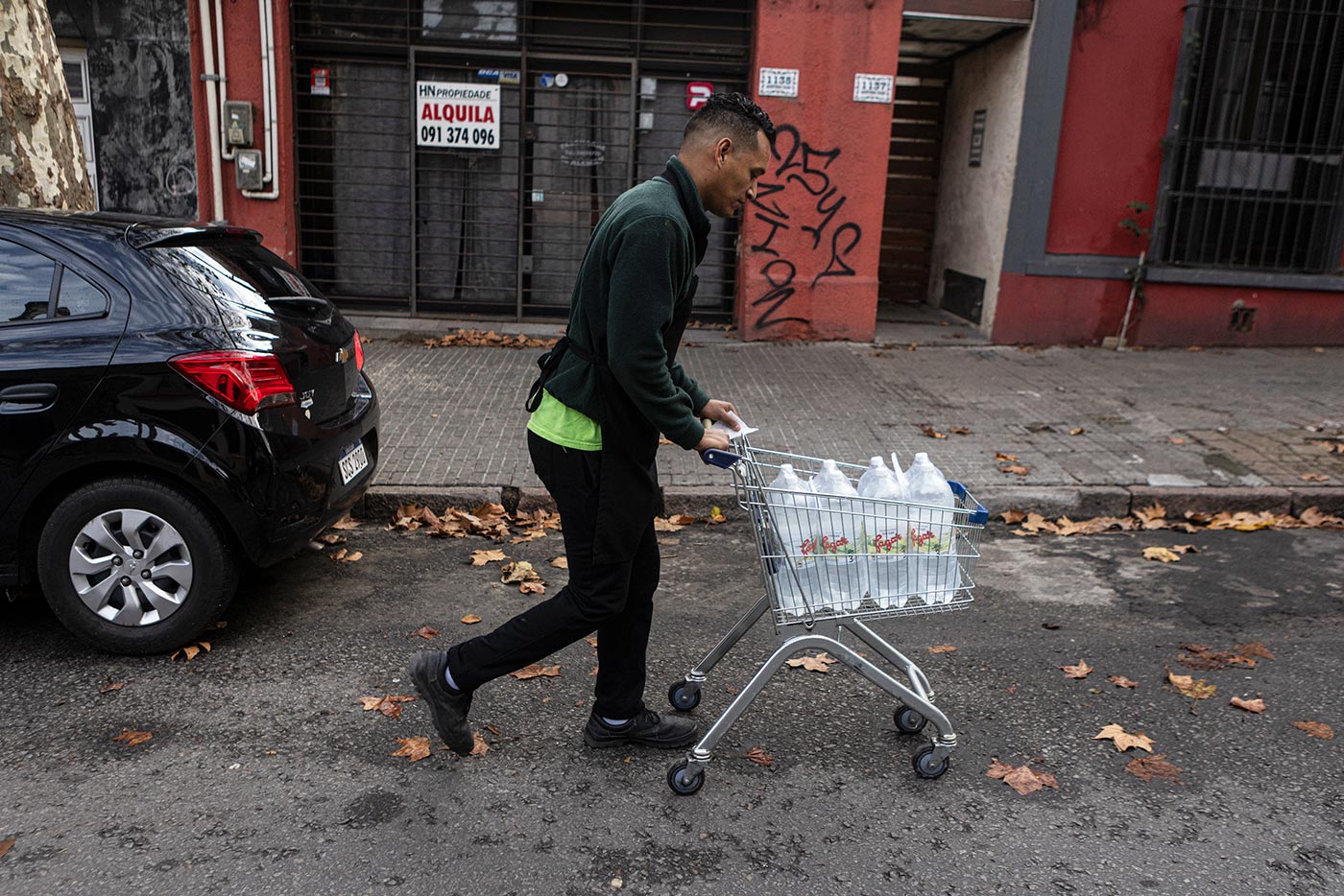 ​​A delivery man carts bottled water down the street in Uruguay’s capital, Montevideo - 6 July 2023