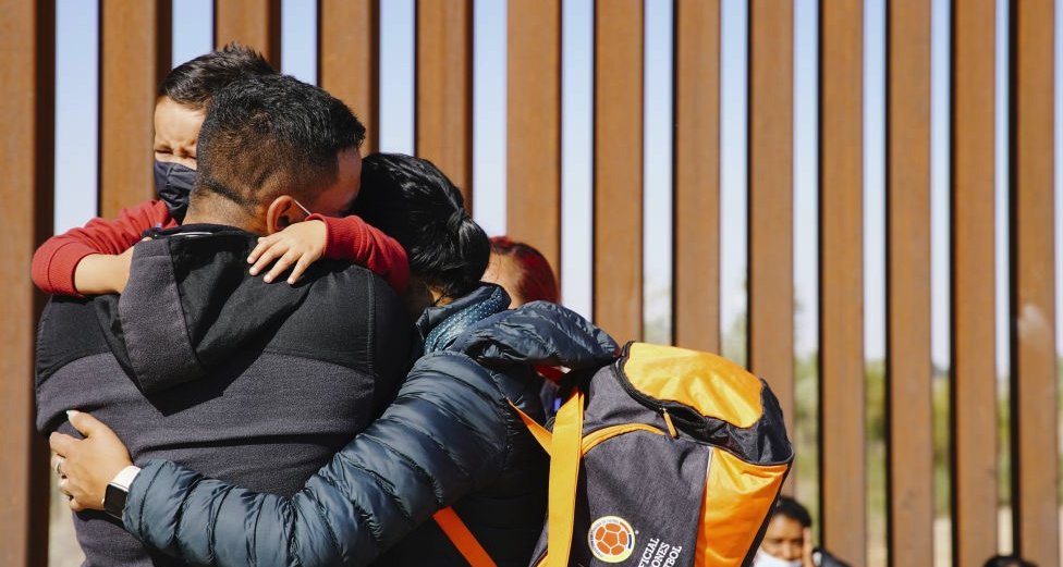 Una familia se abraza en la frontera entre Estados Unidos y México