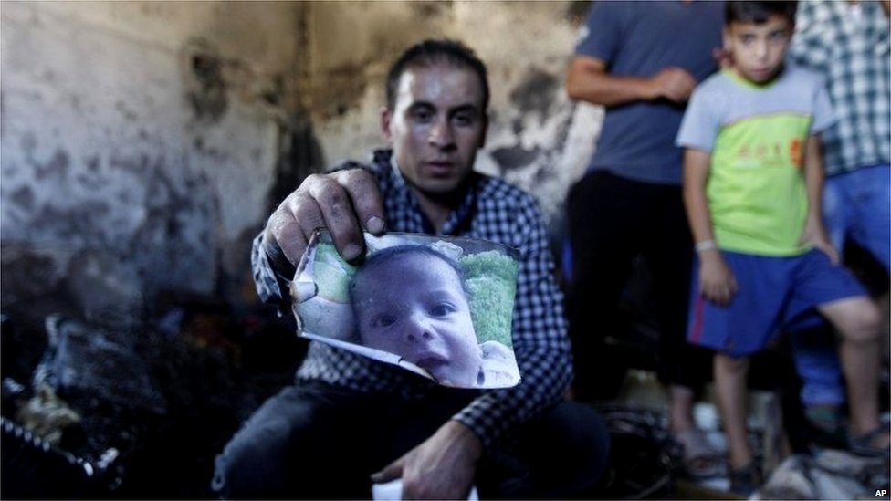 Палестинец держит выжженное фото Али Саада Давабши (31.07.15)