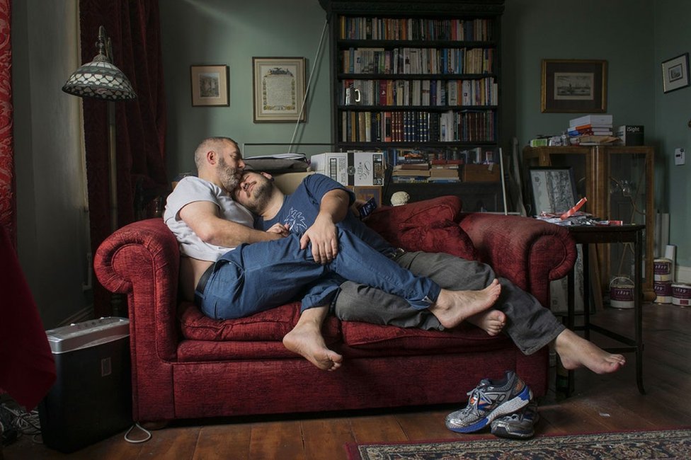 Портрет пары мужчин на диване, обнимающихся